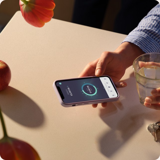 A phone in the hands with the homescreen of the Starling Bank mobile app
