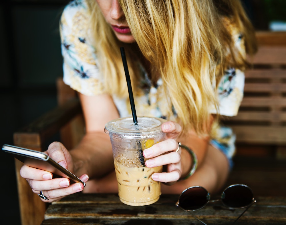 woman drinking coffee with a phone