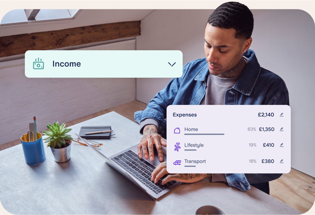 Man wearing a denim shirt working out his expenses on his laptop