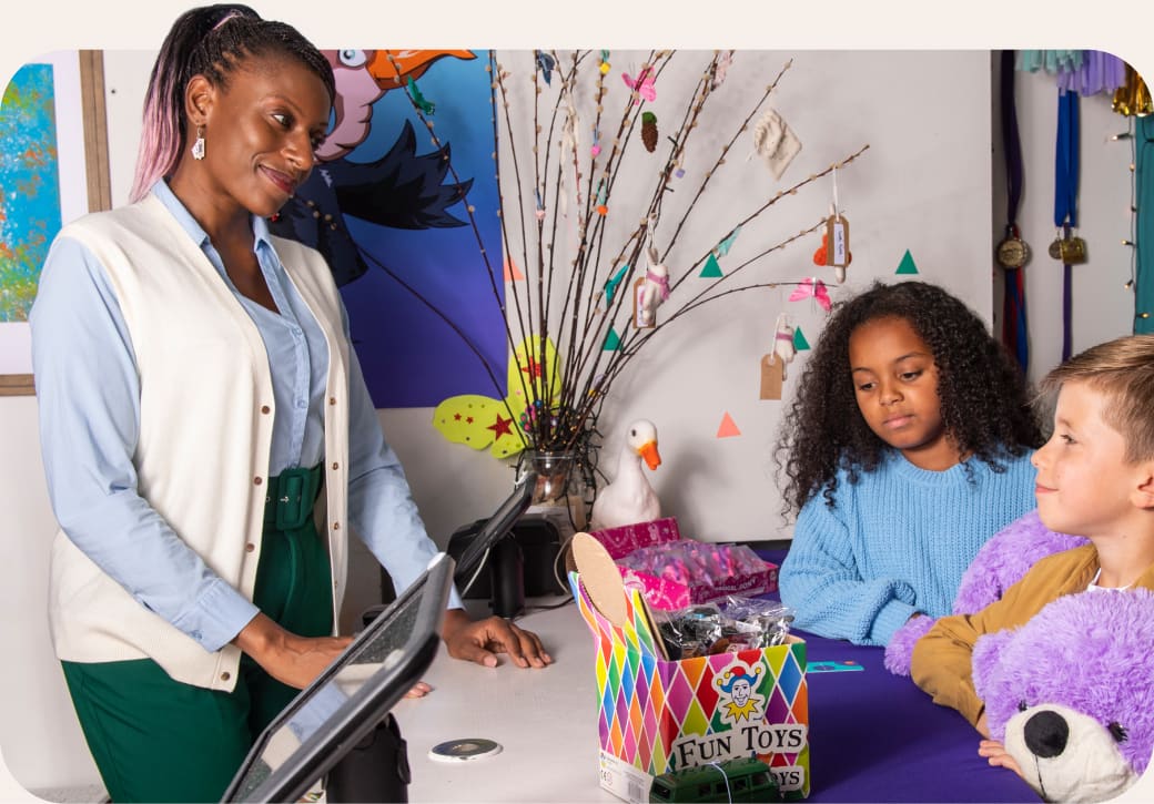 Two children holding purple teddy at cashier