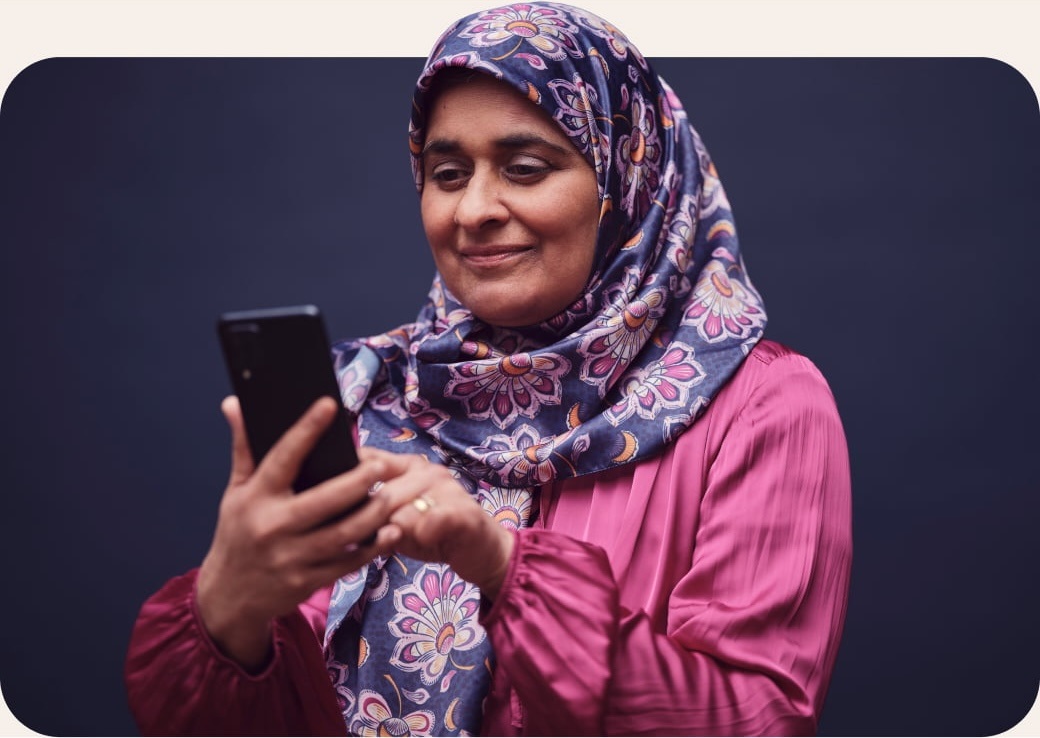 Woman wearing floral headscarf scrolling through her phone