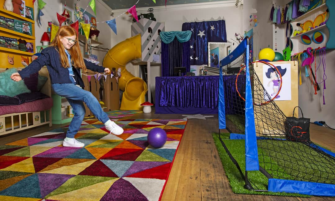 Girl playing football in playroom