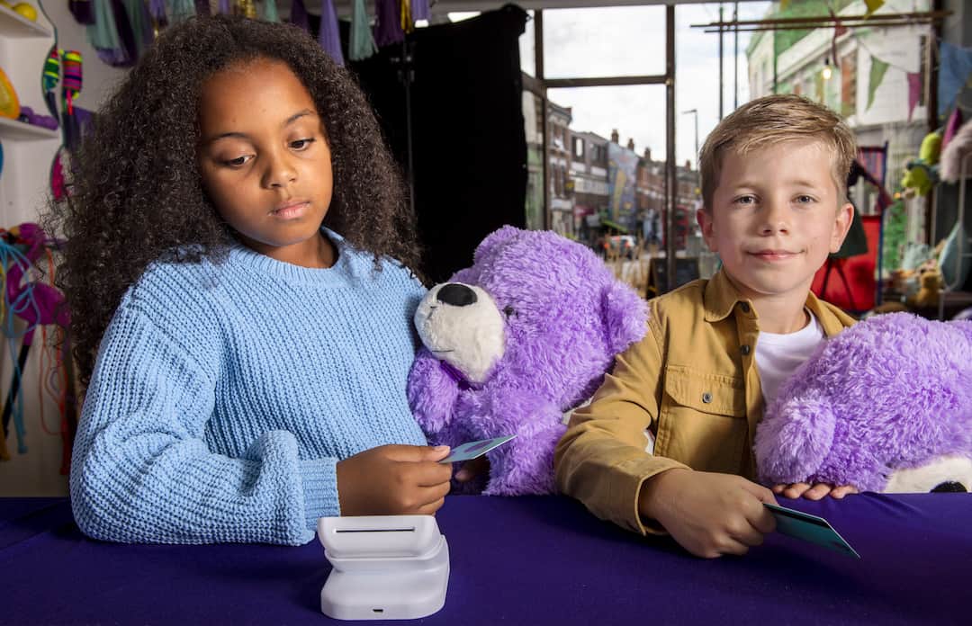 Two kids tapping card on card reader