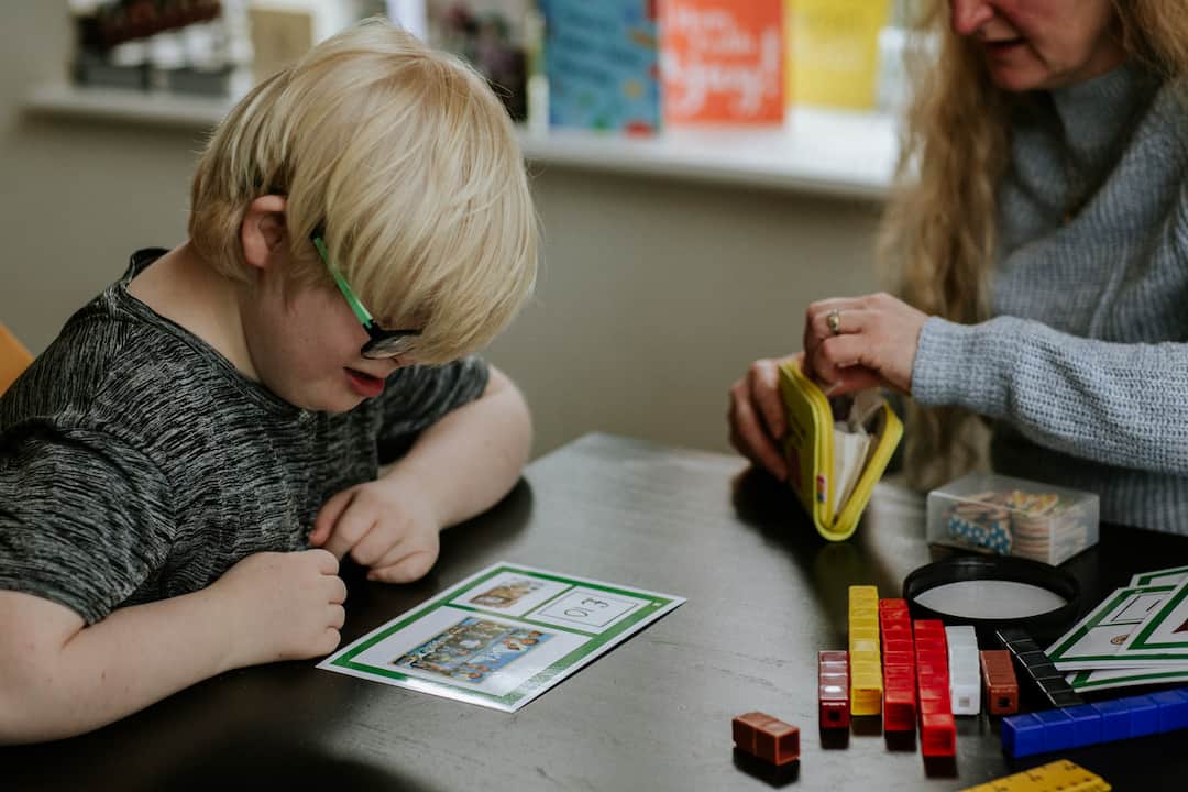 Young boy reading and learning about money at table