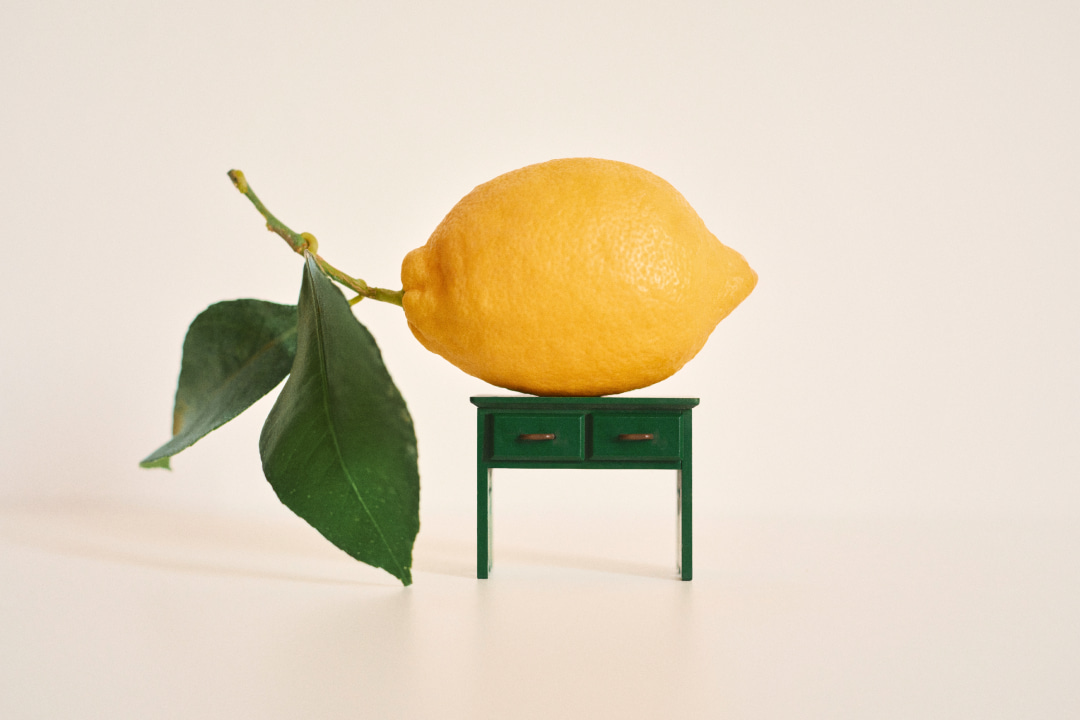 Creative photograph of a lemon on top of a doll's house green table