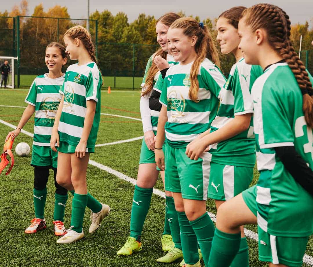 Girls lined up on a football pitch during training