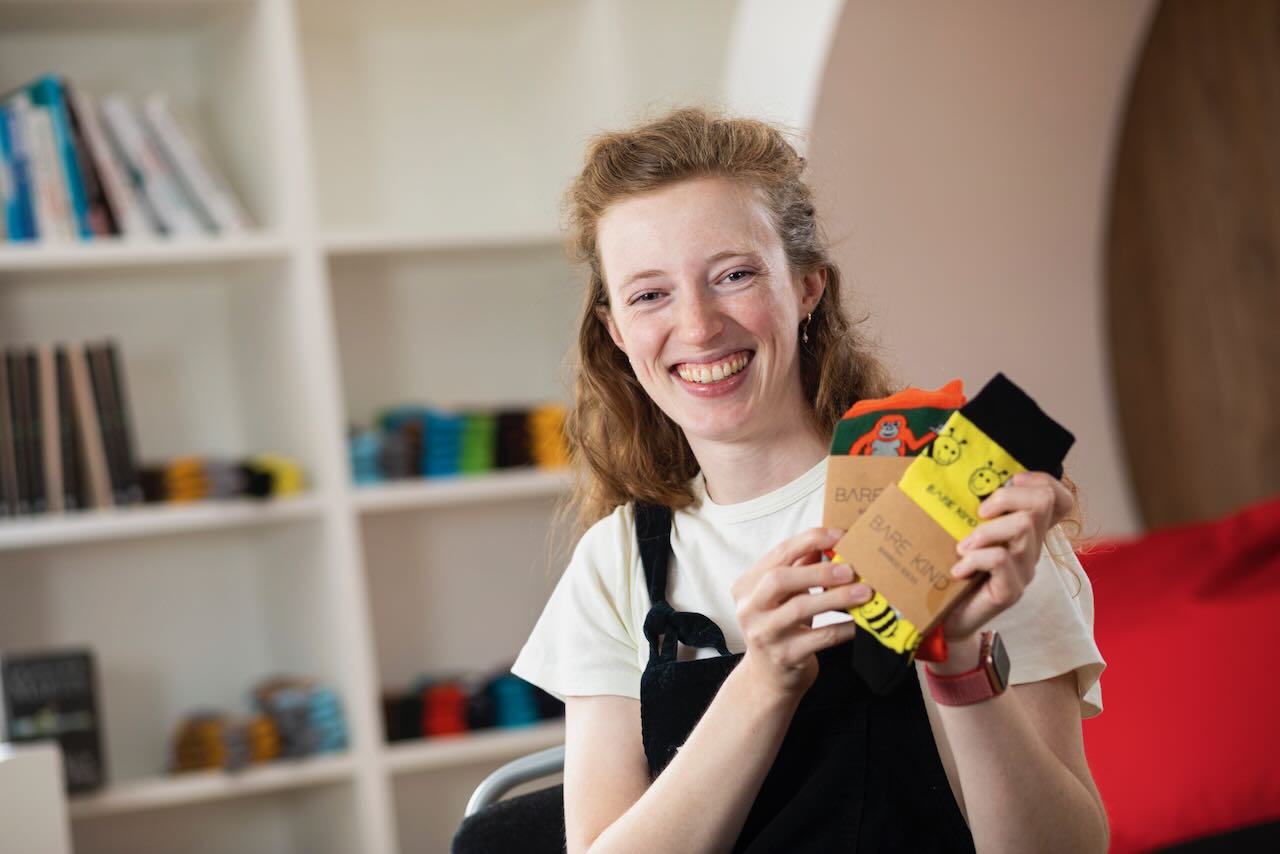 Lucy Jeffrey holding two pairs of Bare Kind socks