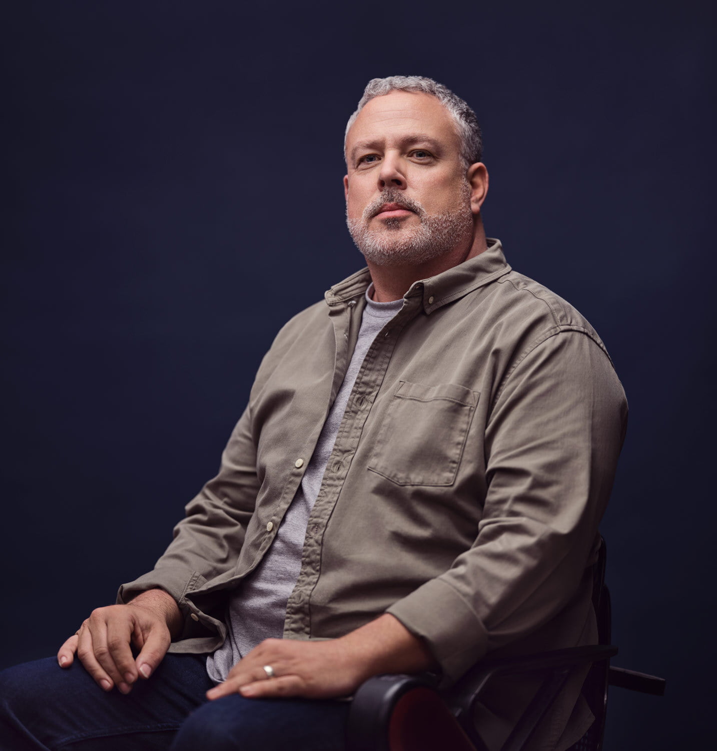 Seated man staring towards the camera.
