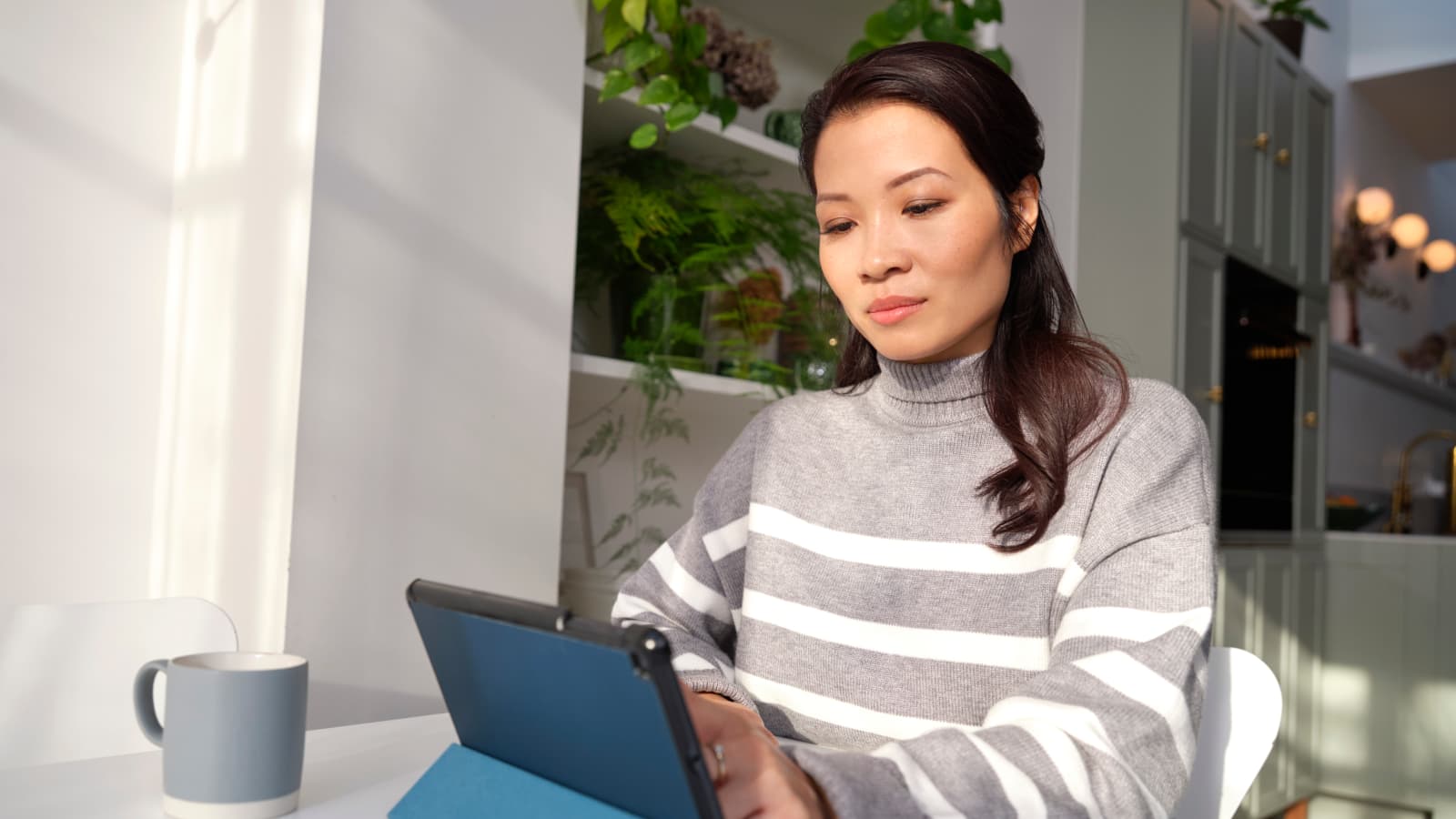 A woman at an ipad in her home