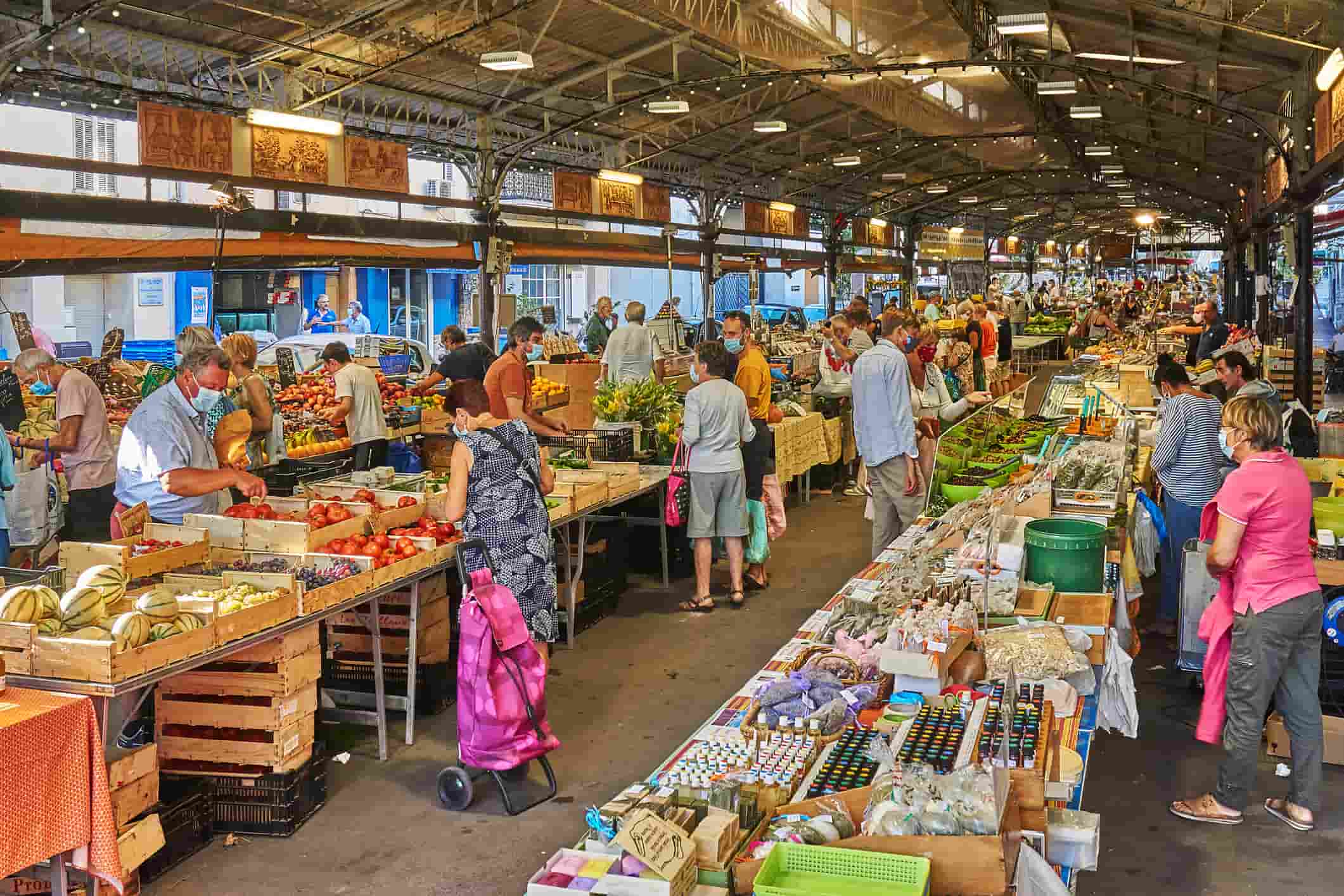 Various people at a market selling food items and other goods