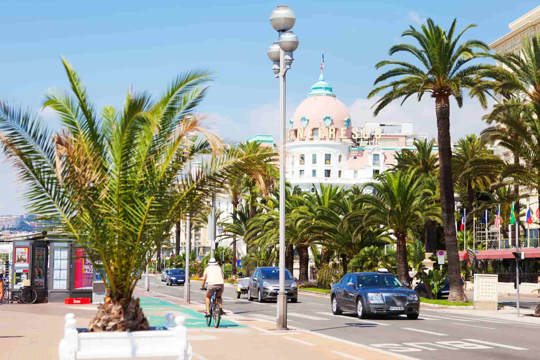 A stretch of road in the South of France with palm trees on the sides of the road