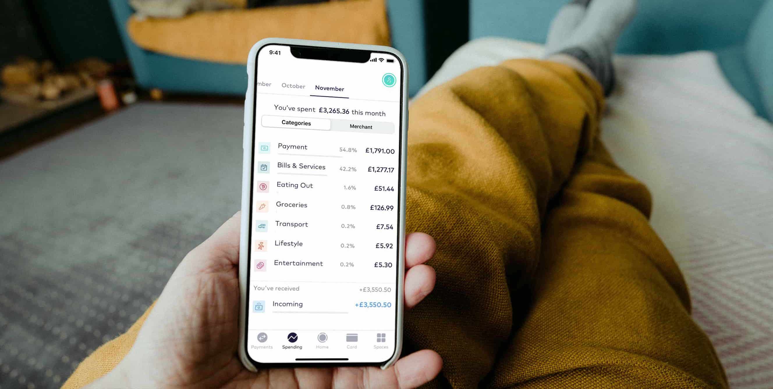 Mobile phone showing the app, with money spent in categories