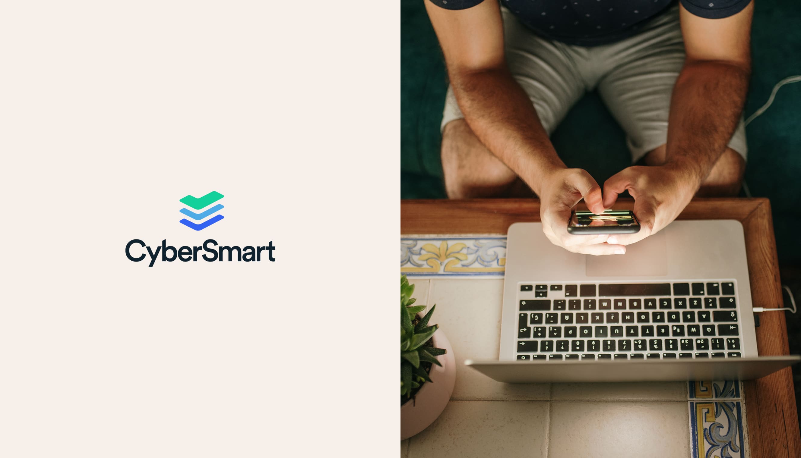 Someone sitting with a laptop, holding a mobile phone
