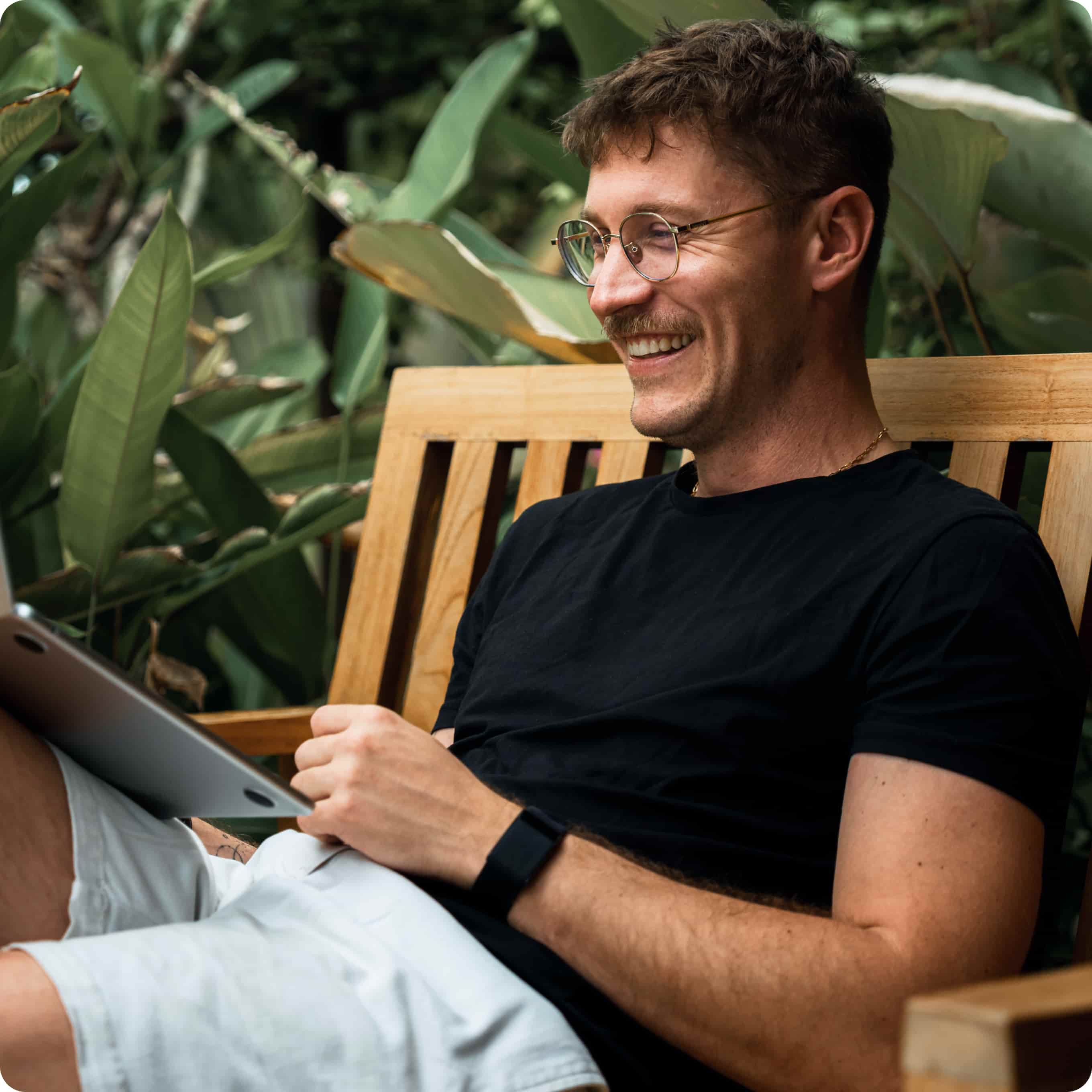 An image showing a man smiling at his laptop