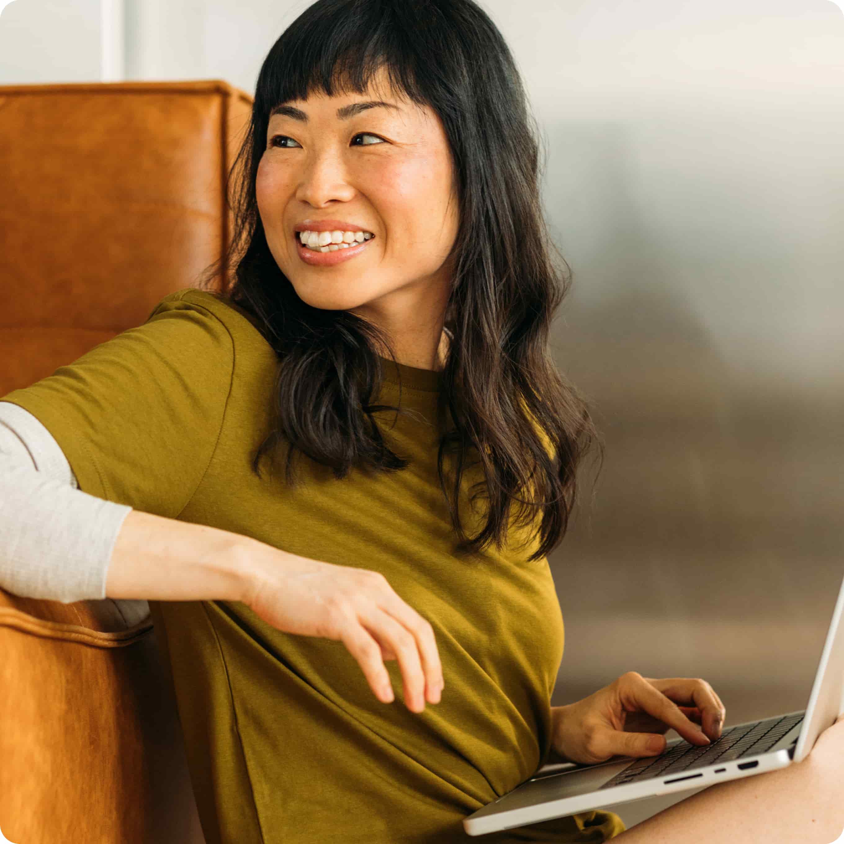 Picture of an Asian woman with a laptop smiling