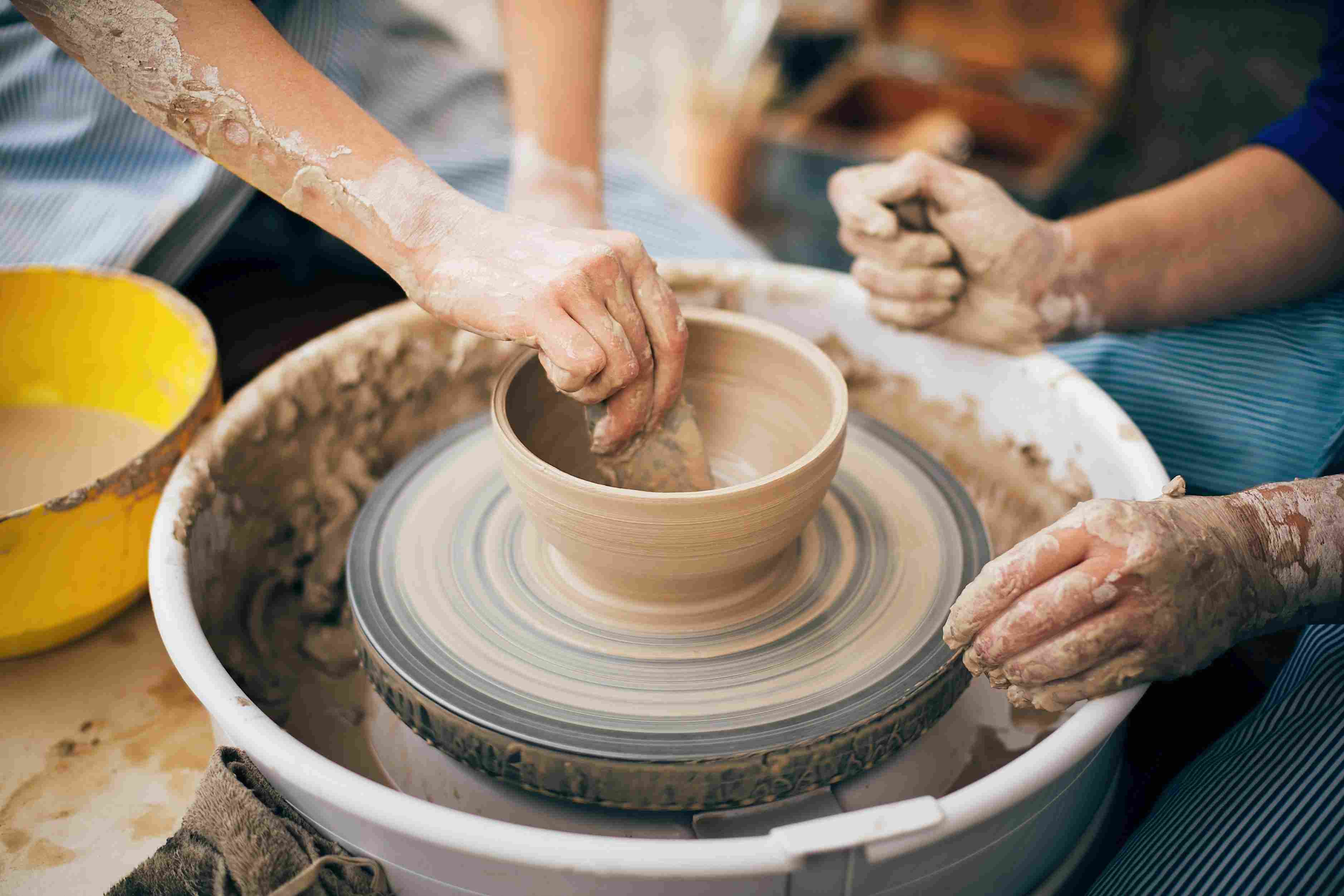 People creating a ceramic bowl together