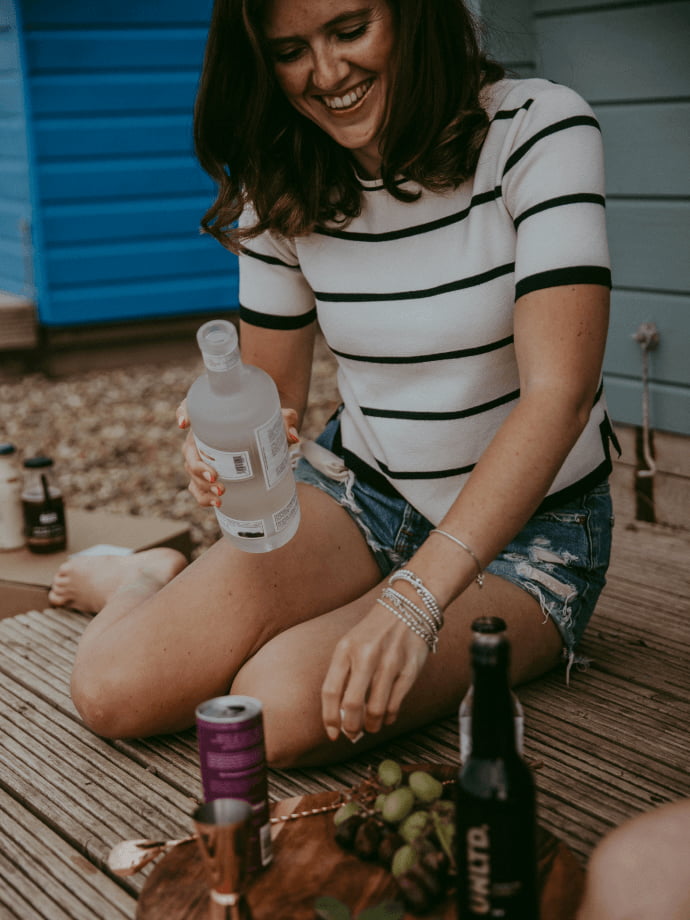 Gemma Mills sitting on the decking pouring a drink