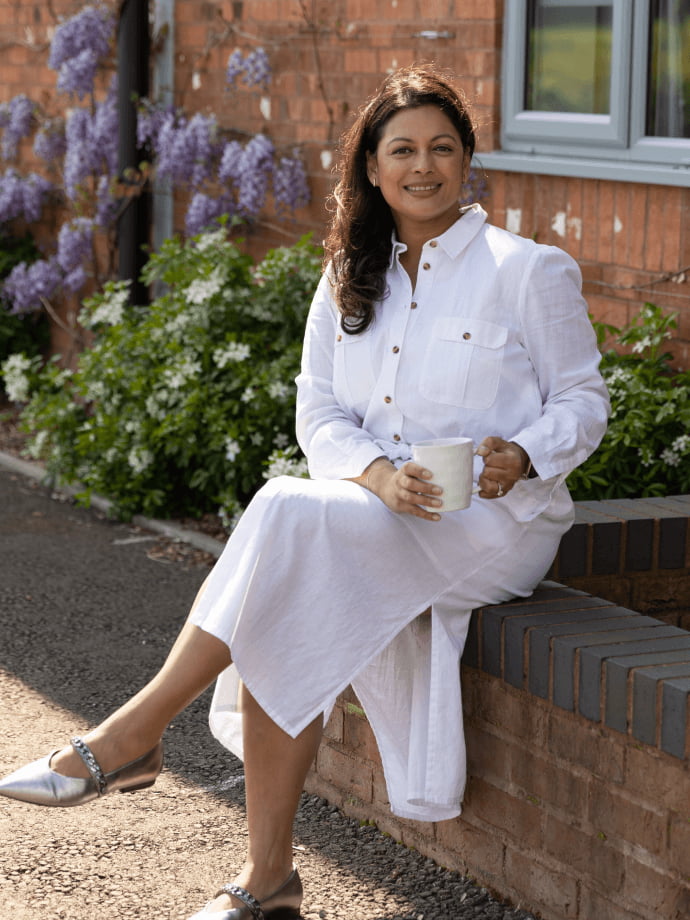 Smita Sinha sitting on a wall