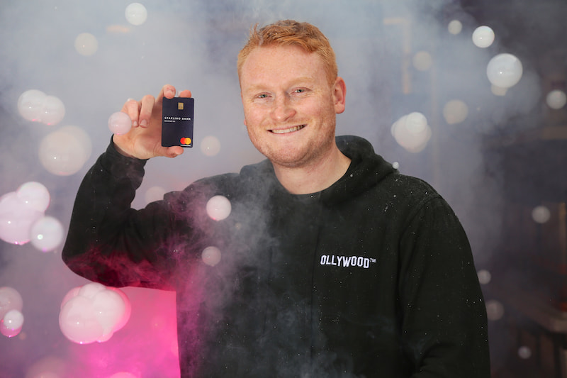 Oliver smiles holding his Starling business card