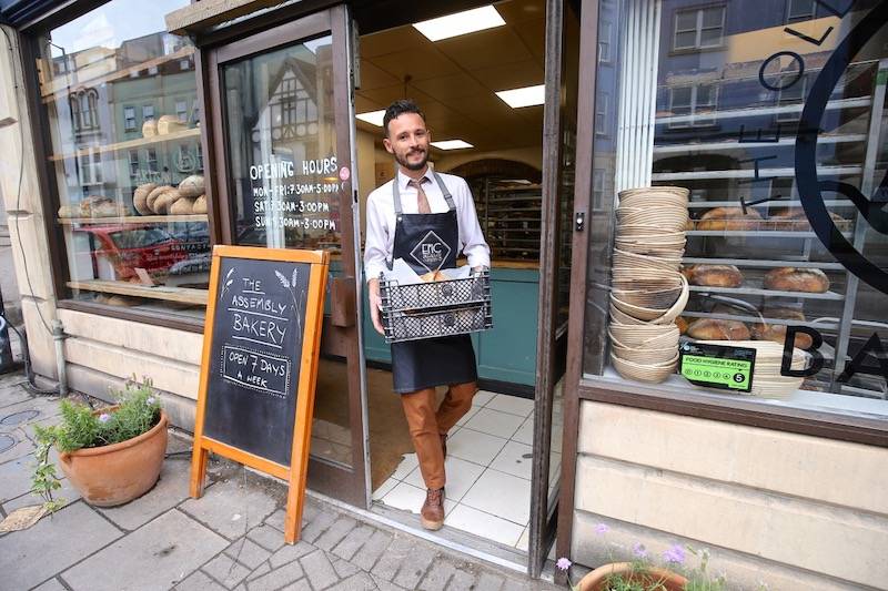 Ollie stands in the doorway of a bakery.