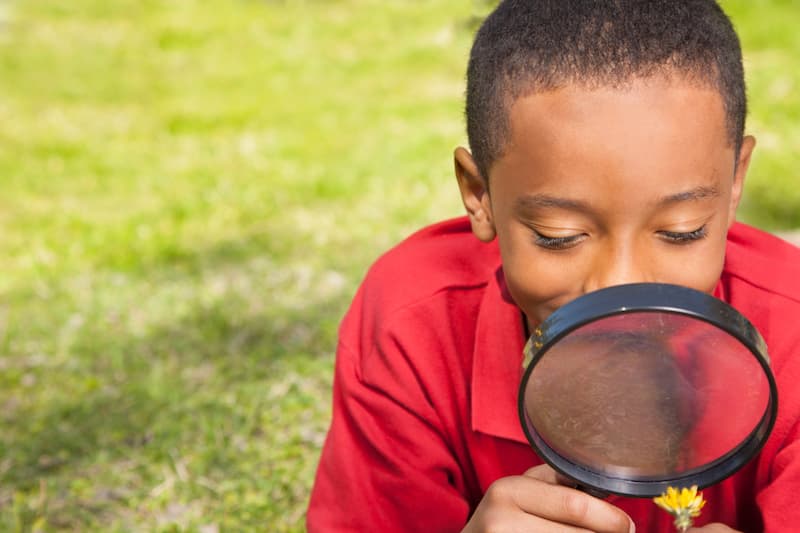 A child looking through a magnifying glass