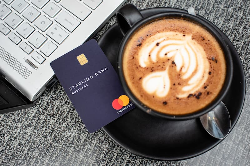 A navy business Starling card next to a coffee