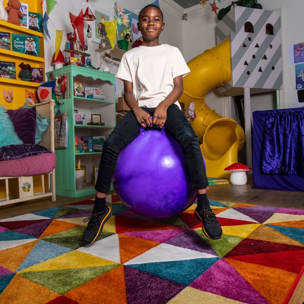 Boy in a playroom on a bouncy ball