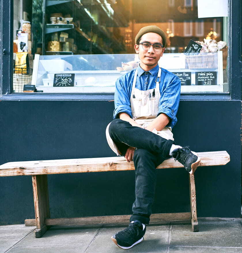 Man sitting on a bench outside shop