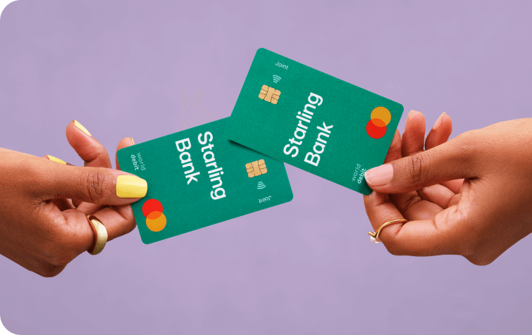 Hands holding two Starling Bank cards